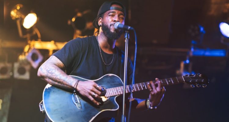 Man-playing-guitair-and-singing-into-microphone